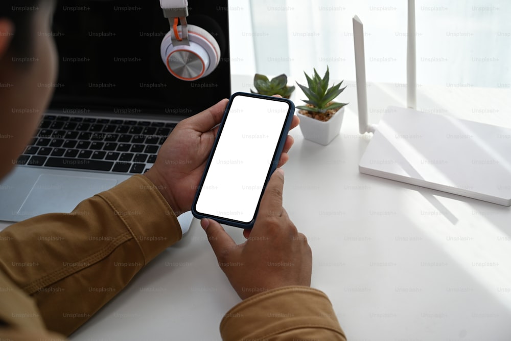 Close up view of man hands using smart phone connecting wifi internet at home.