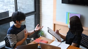 Female psychiatrist having consultation on disease or mental illness with her patient in medical clinic or hospital.