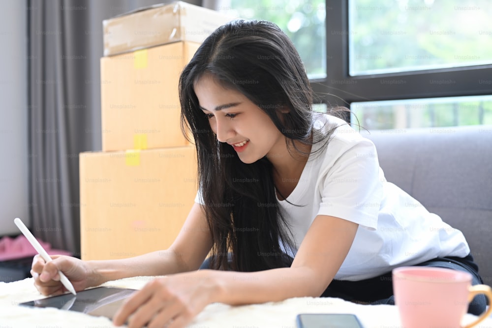 Lächelndes junges Unternehmen Start-up-Online-Verkäufer Besitzer mit digitalem Tablet zur Überprüfung der Kundenbestellungen zu Hause.