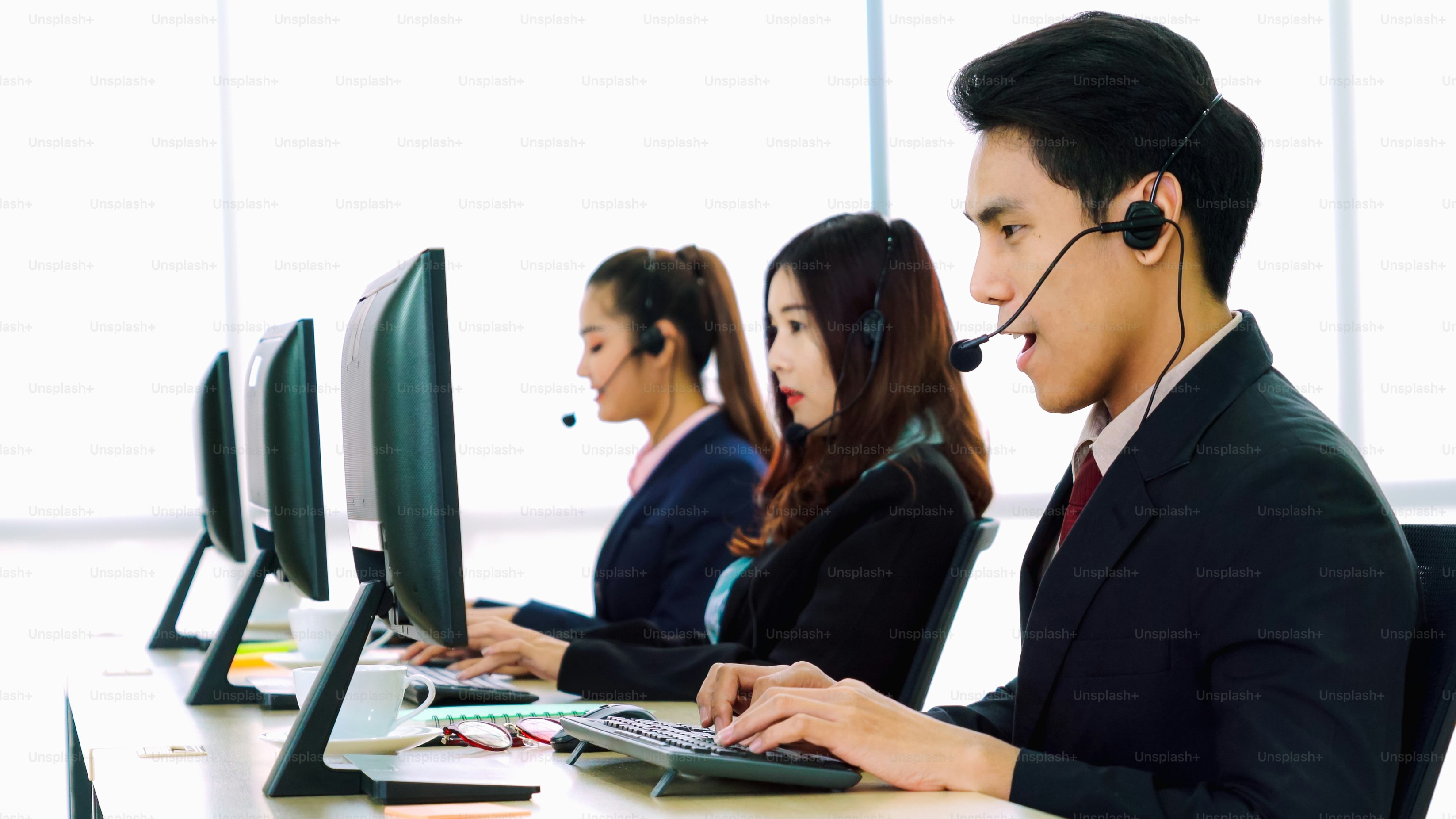 Business people wearing headset working in office to support remote customer or colleague. Call center, telemarketing, customer support agent provide service on telephone video conference call.