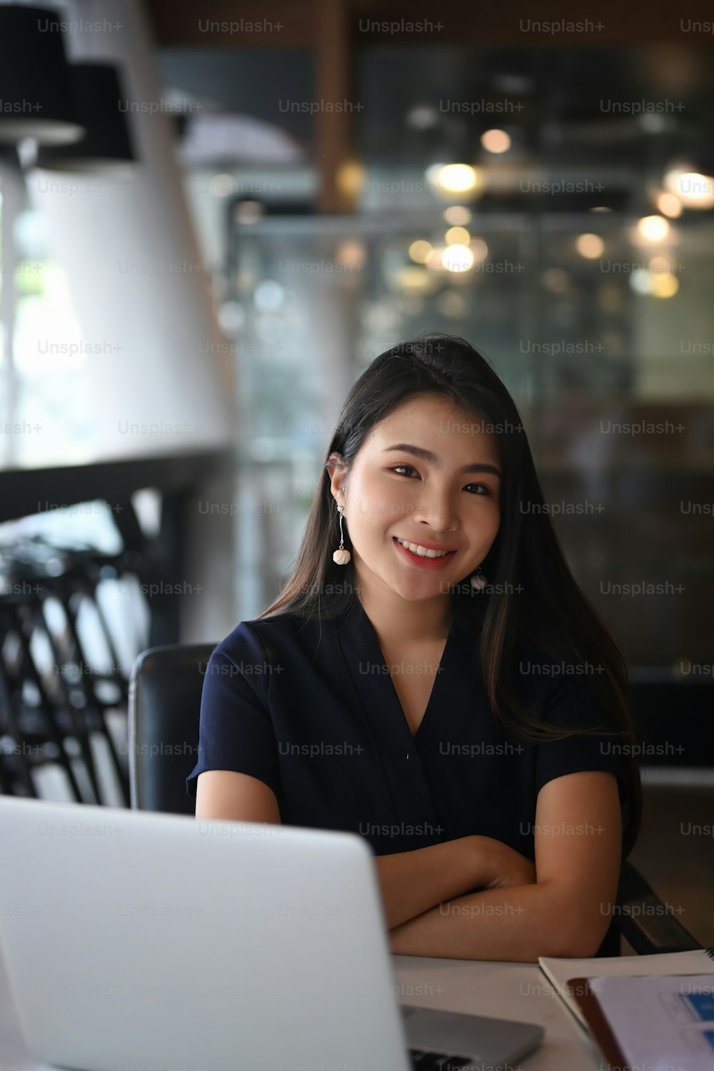 Portrait of confident businesswoman sitting at office desk and smiling to camera.