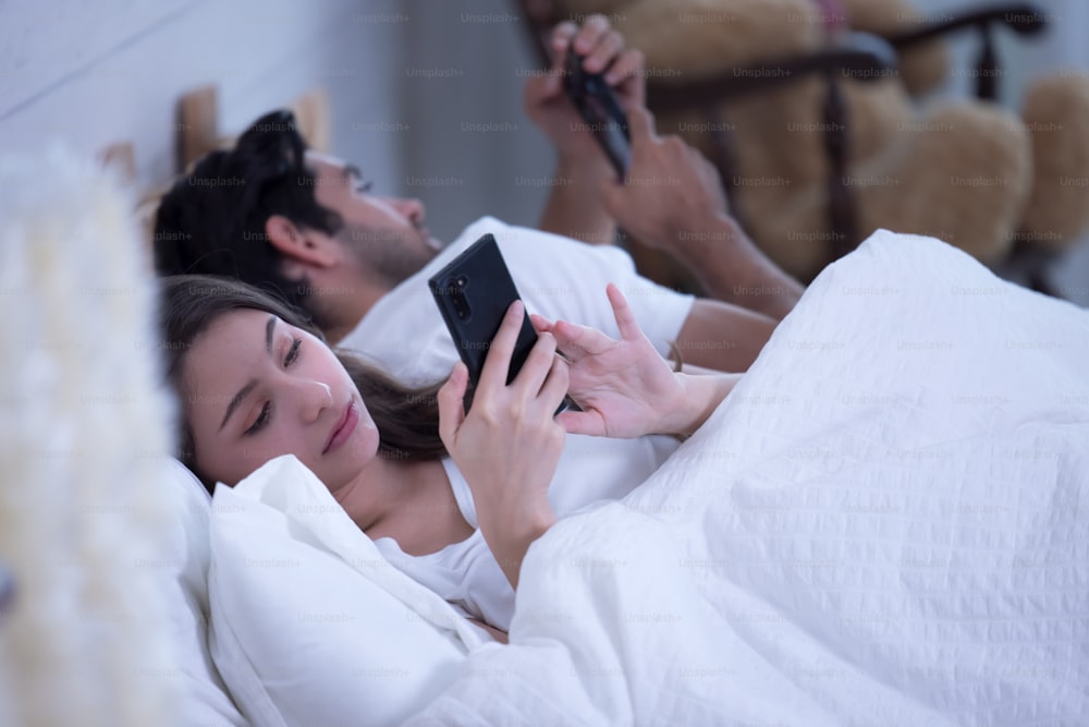 Young Couple In A Bed With Mobile Phones