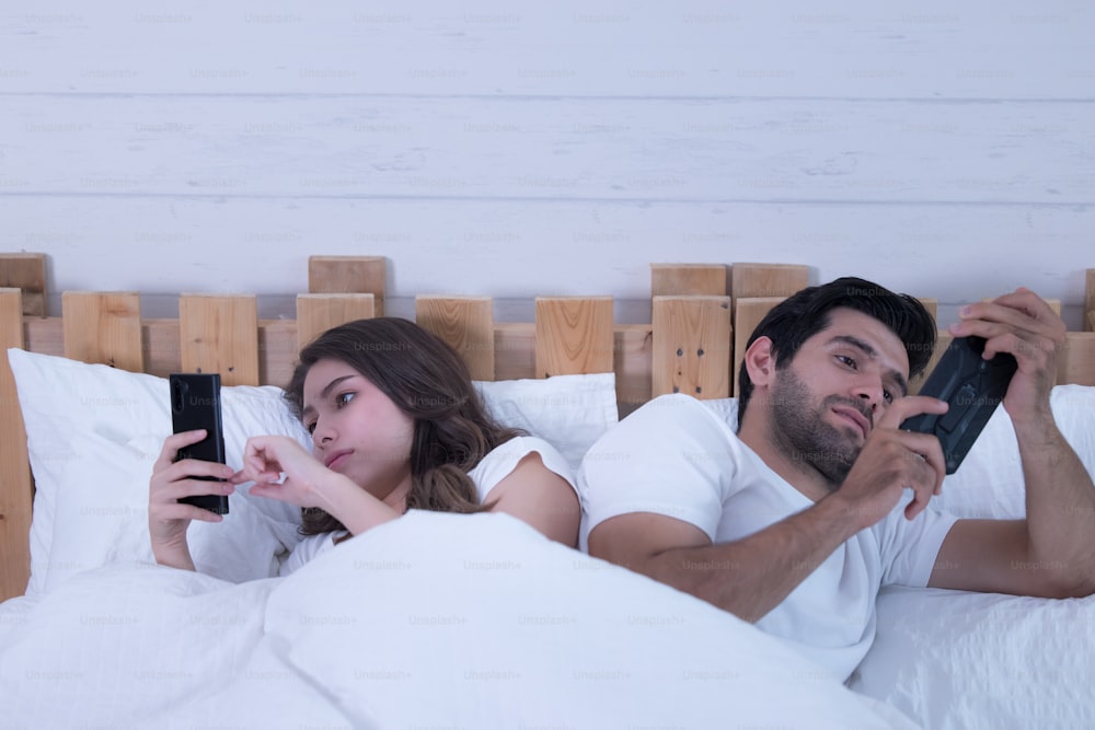 Young Couple In A Bed With Mobile Phones