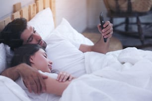 Young Couple In A Bed With Mobile Phones