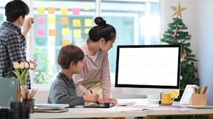 デジタルタブレットを使用し、オフィスでビジネス戦略を議論するクリエイティブデザイナーのグループ。