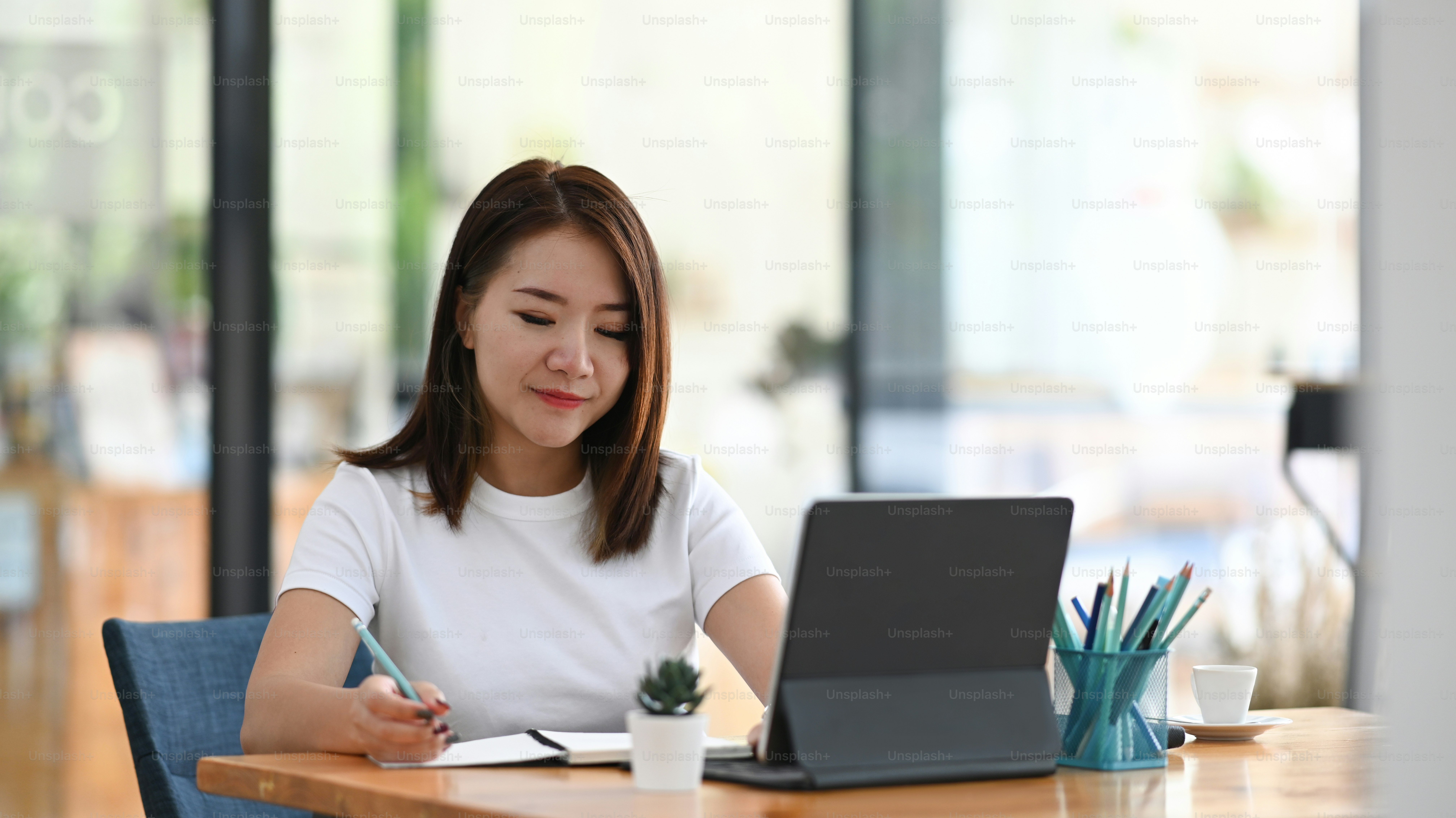 Young woman freelancer working on tablet computer for checking ...