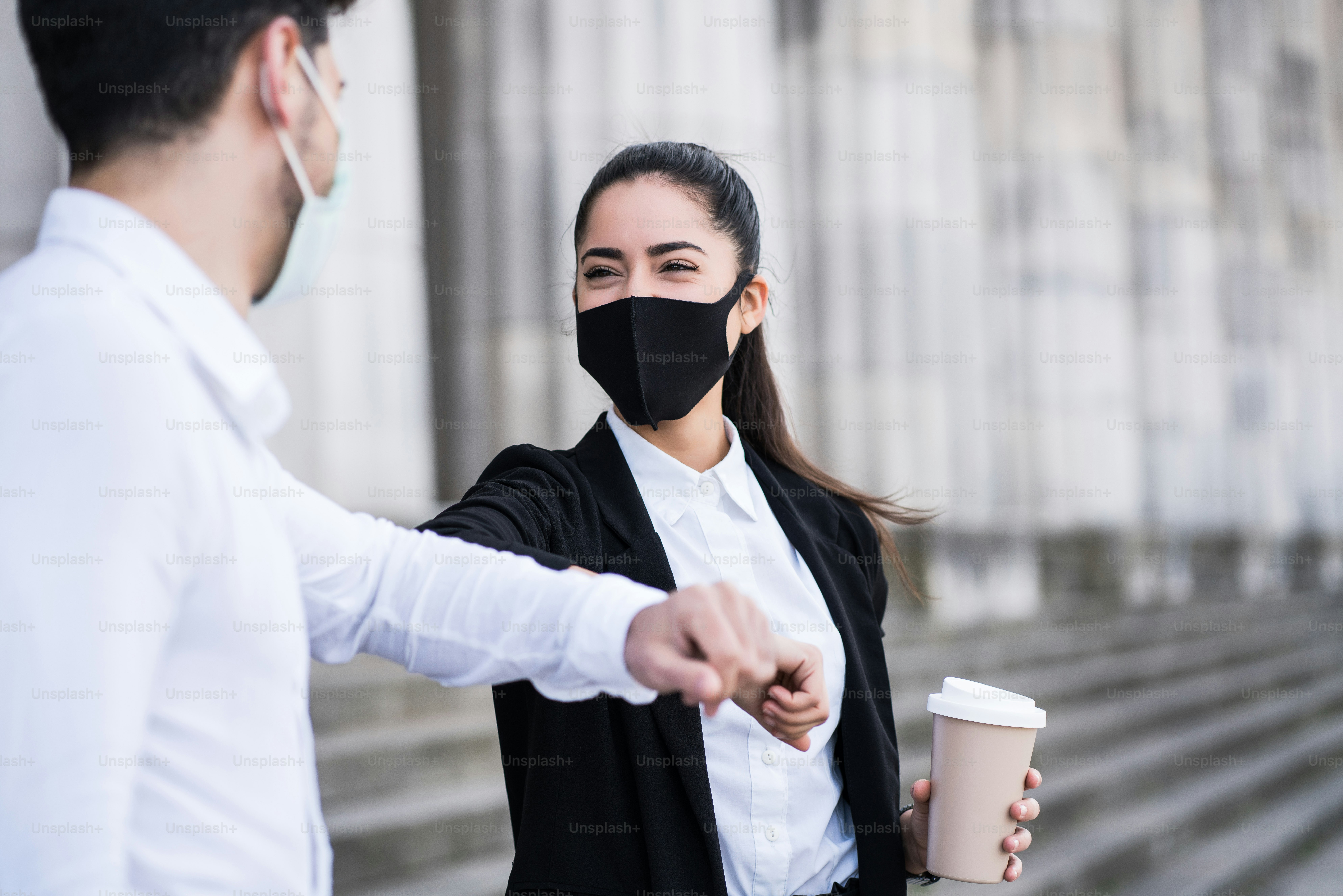 Portrait of two business people bumping elbows for greeting each other outdoors. Business concept. New normal lifestyle concept.