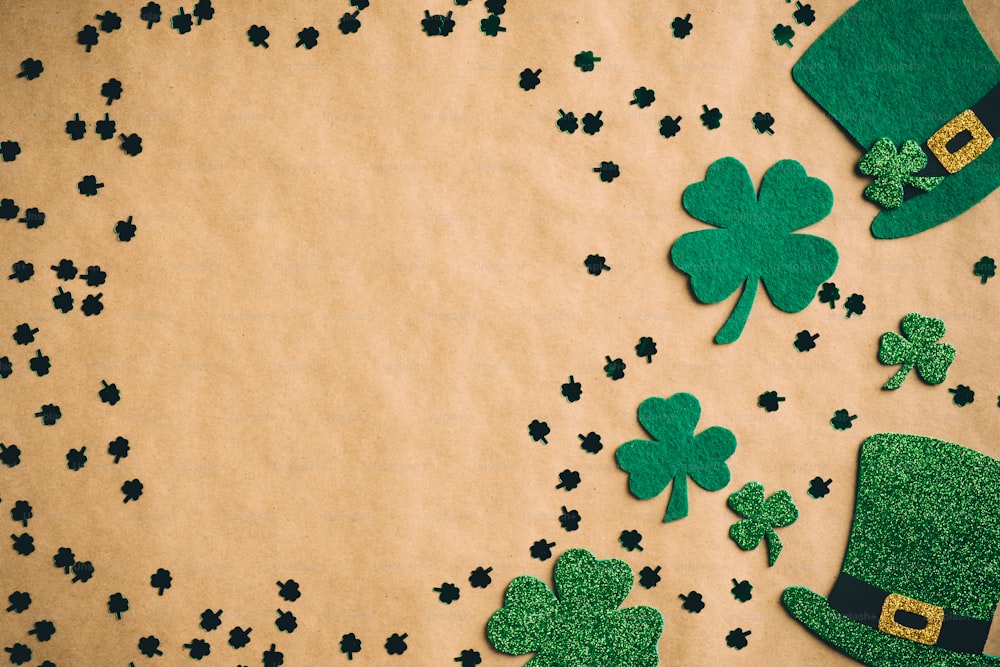 Happy Saint Patrick's Day Konzept. Flache Lay-Komposition mit grünen Hüten und Kleeblattblättern auf Kraftpapierhintergrund. St Patrickâs Day Bannerdesign, Postervorlage.