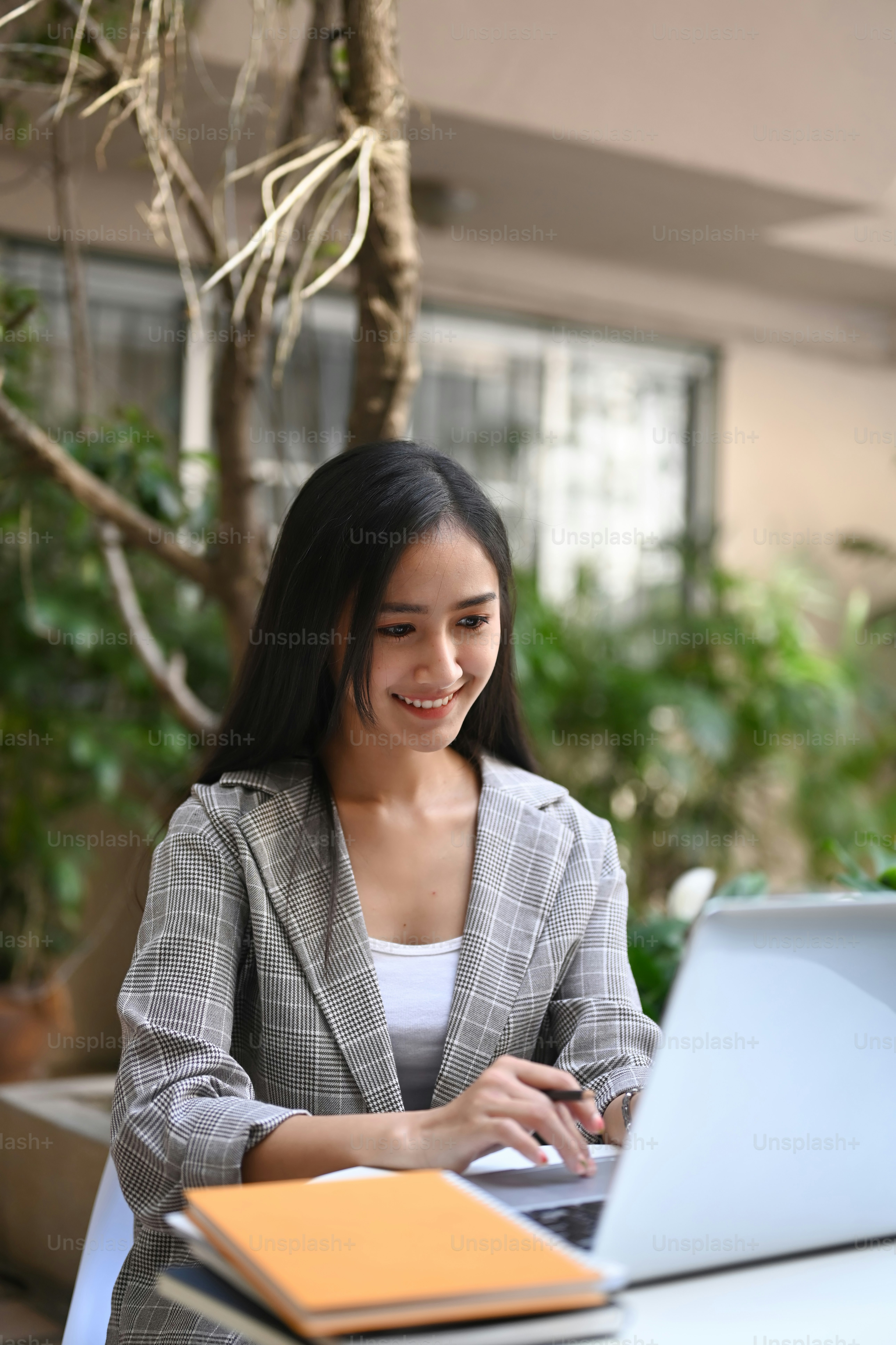 Retrato de uma jovem empreendedora confiante que trabalha com laptop enquanto está sentada no café.