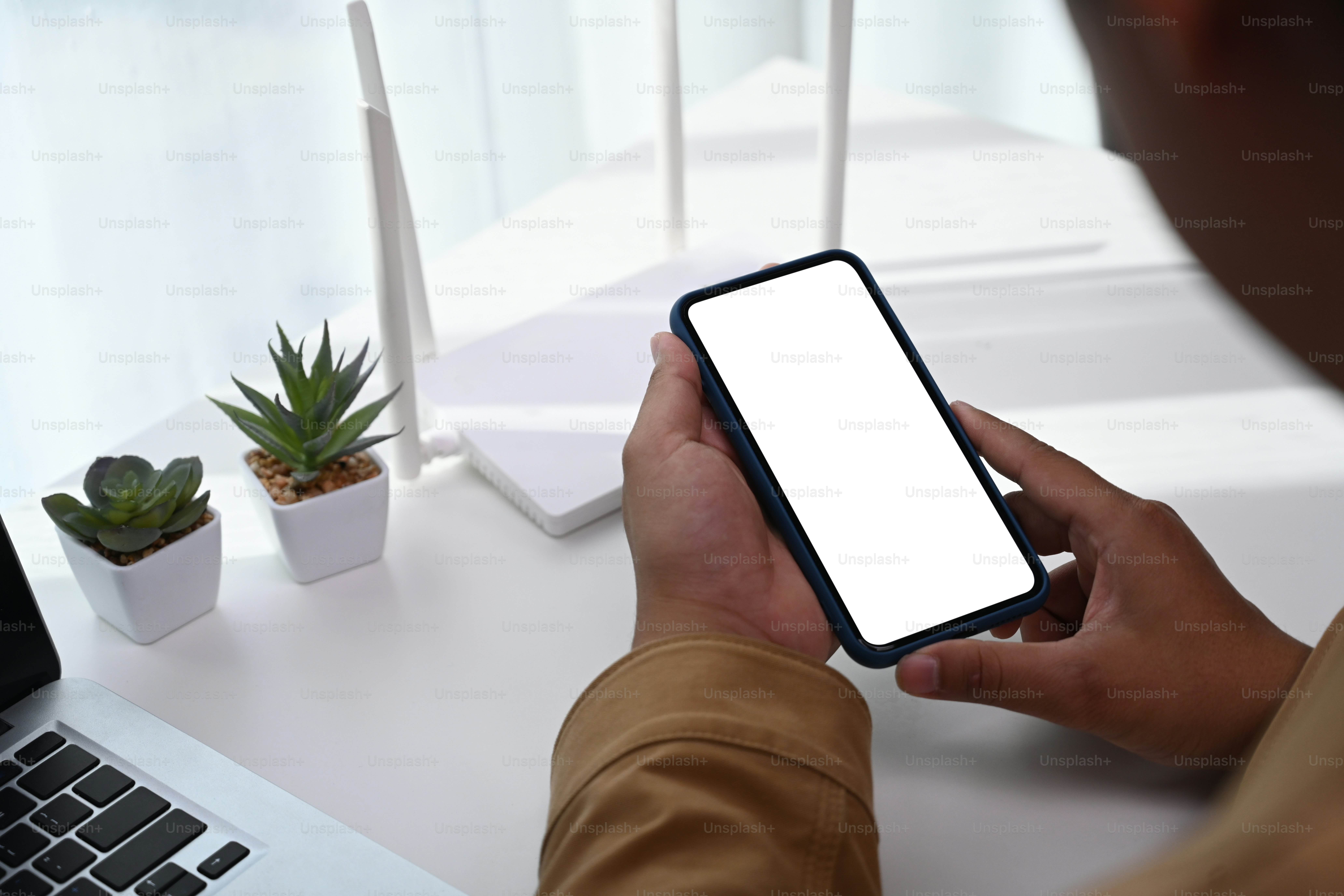 Vue rapprochée d’un homme utilisant un téléphone intelligent pour se connecter à Internet ou à une connexion sans fil à la maison.