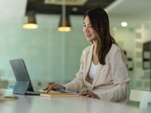 Side view of businesswoman working with digital tablet in glass partition office room