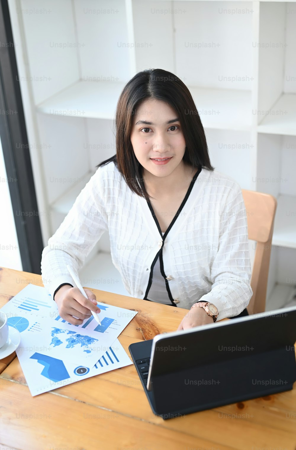 Retrato da empresária que trabalha com laptop e analisa dados de negócios na mesa do escritório.