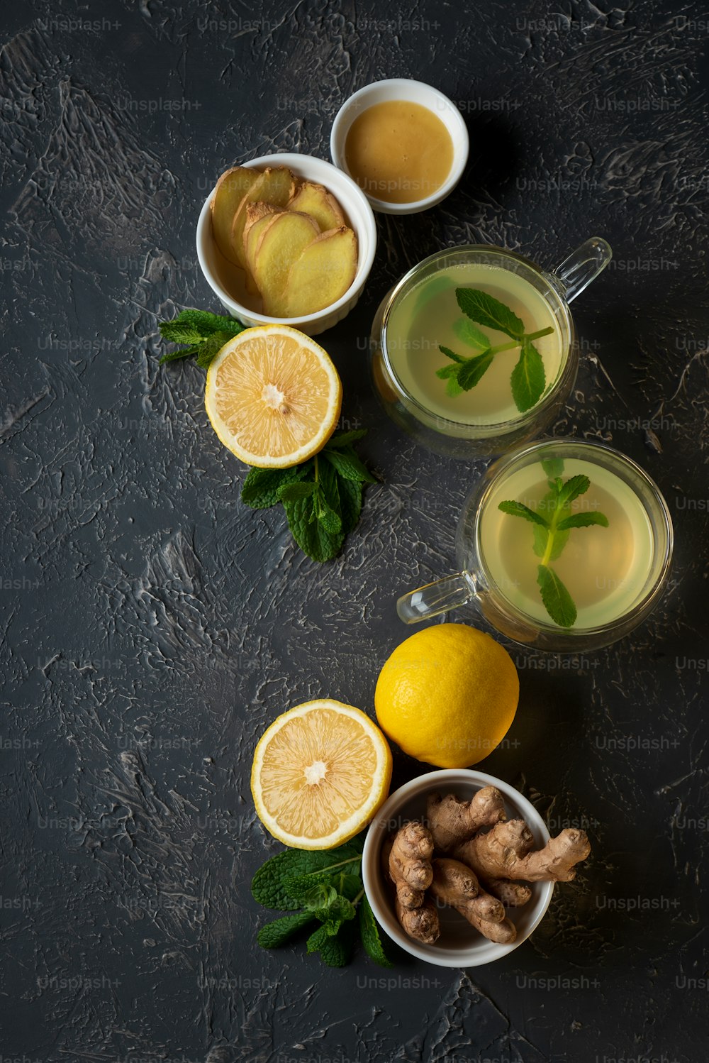Tè allo zenzero con menta, limone e miele su sfondo di cemento. Vista dall'alto