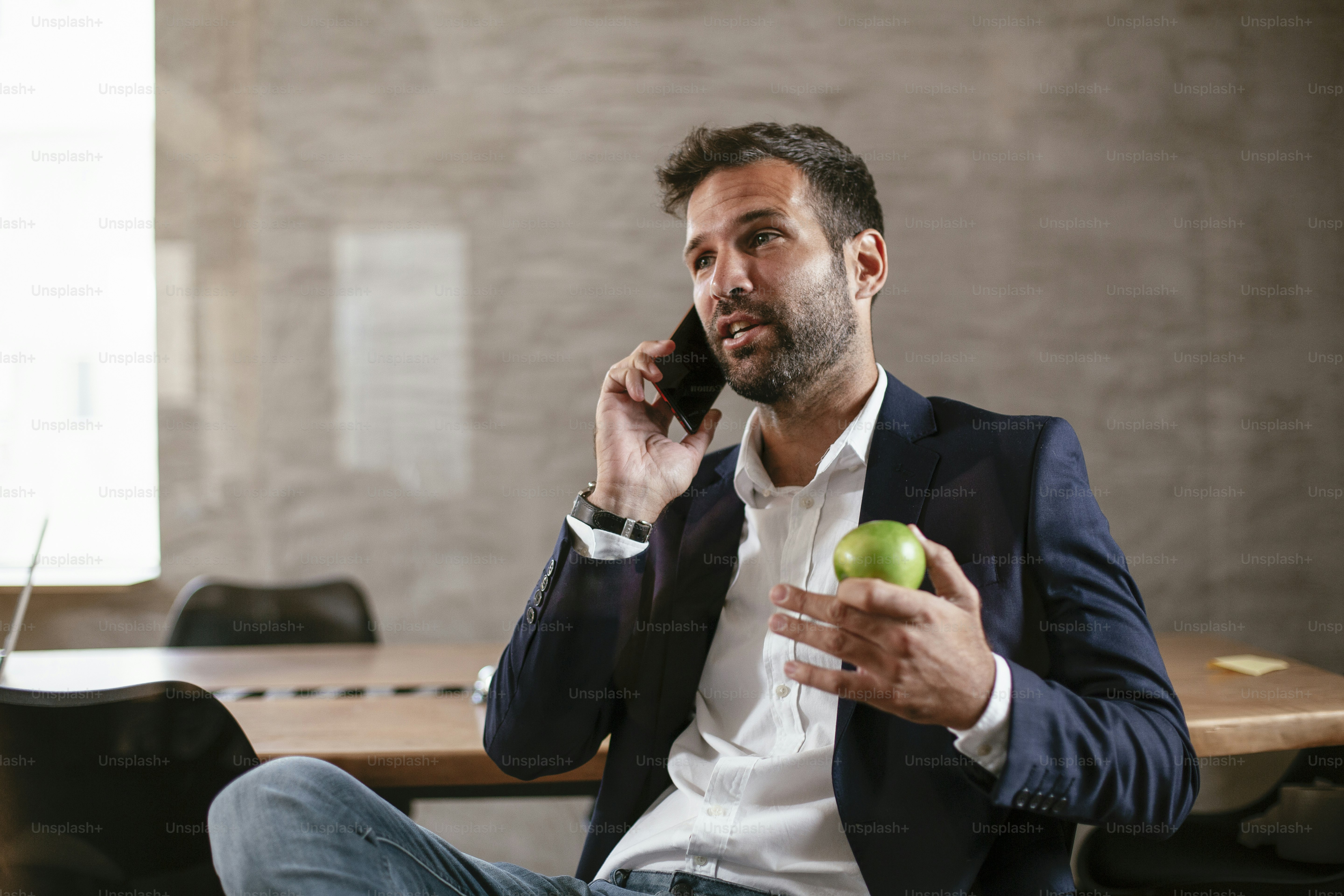 Geschäftsmann im Konferenzraum mit dem Telefon. Hübscher Geschäftsmann, der mit dem Telefon spricht.