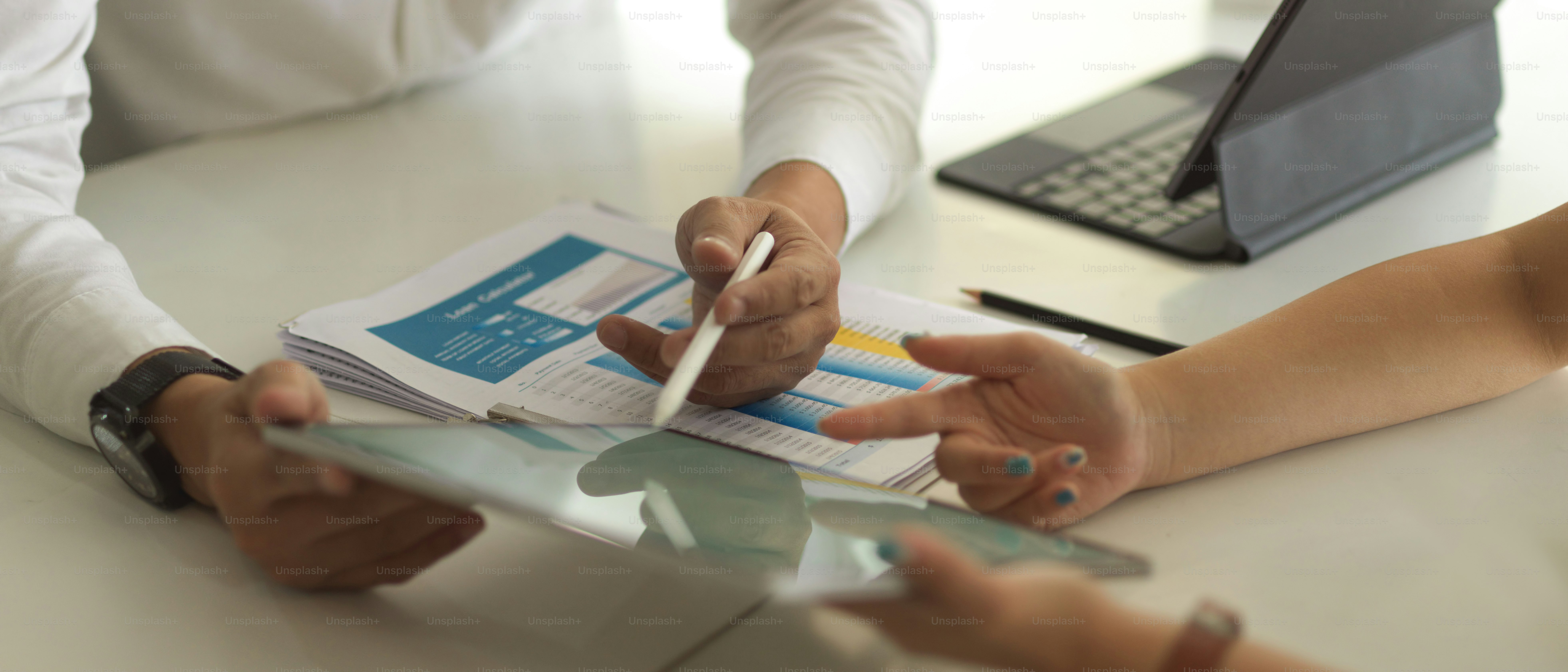 Cropped shot of businesspeople hands working digital tablet and paperwork on meeting table