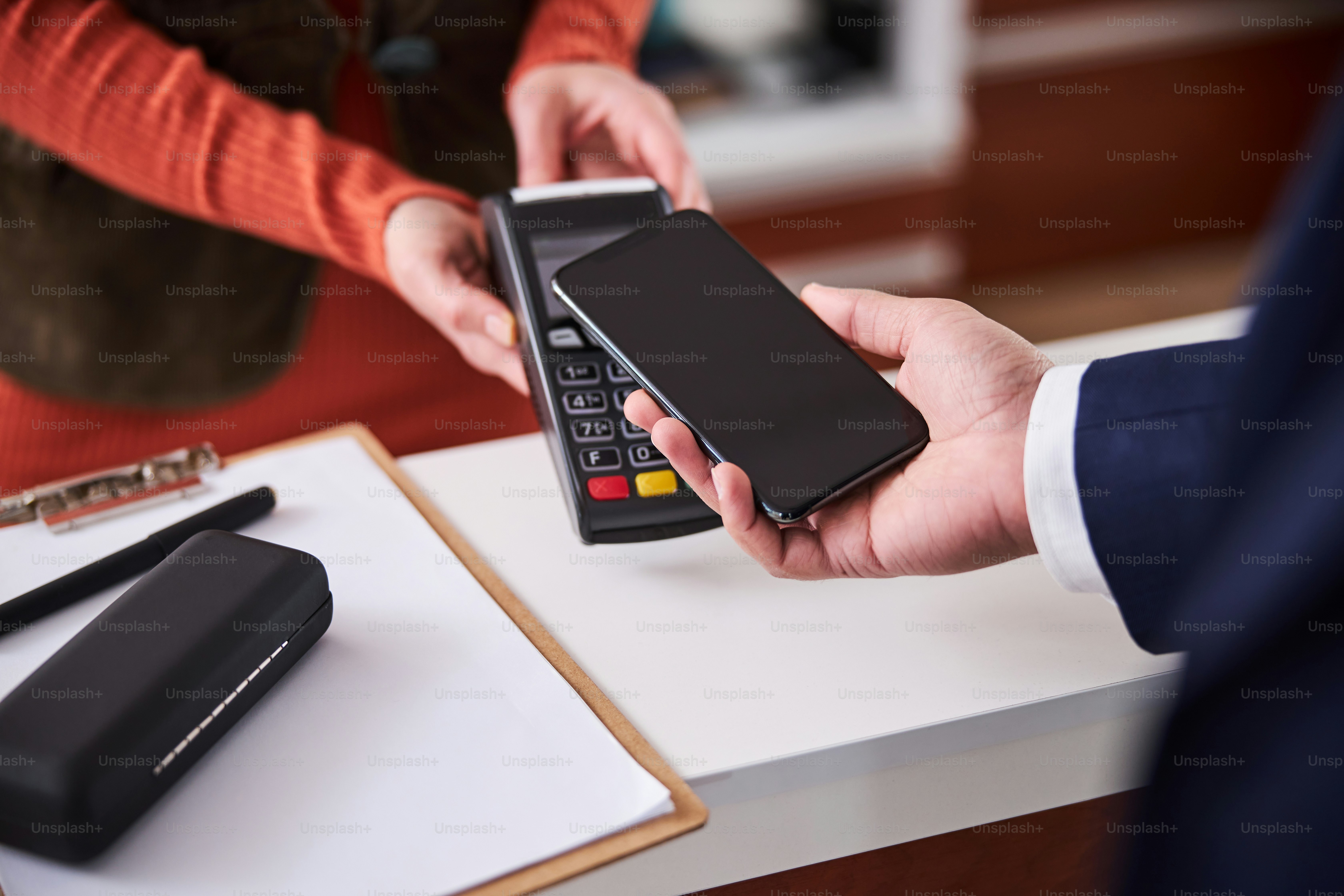 Beschnittenes Foto eines männlichen Kunden, der seine neue Brille in einem Optikergeschäft bezahlt