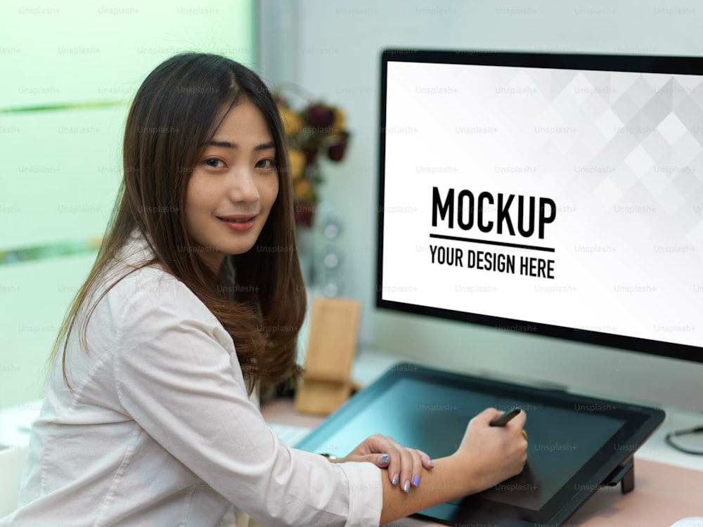 Portrait of businesswoman working with drawing tablet and computer include clipping path in office room