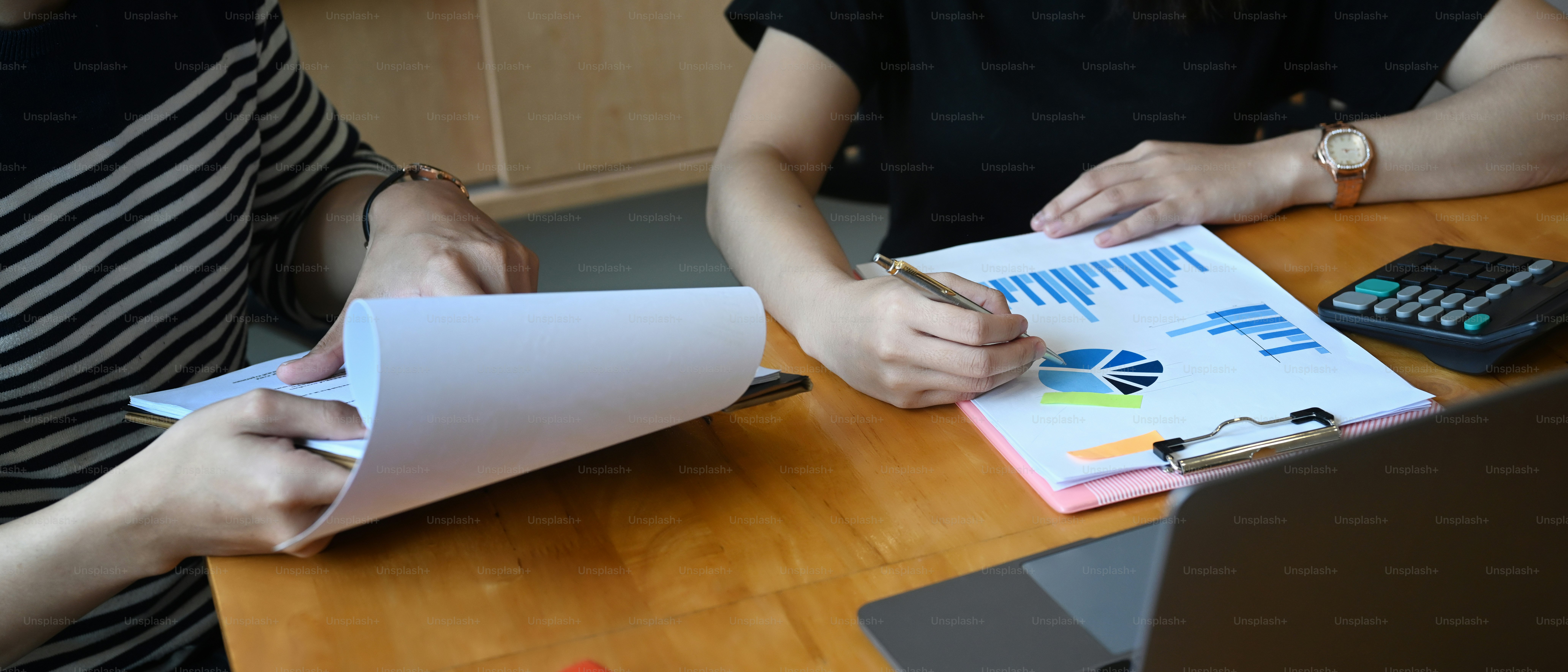 Cropped shot of business people discussing the charts and graphs showing the results of their successful.