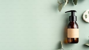 SPA Kosmetikprodukt Branding Mockup. Bernsteinglasspenderflasche für Shampoo oder Duschgel, Luffa und Eukalyptusblätter auf grünem Hintergrund. Draufsicht mit Kopierraum. Natürliches Bio-Schönheitsprodukt