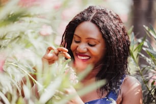 Content Black Woman Smelling Flowers in Park