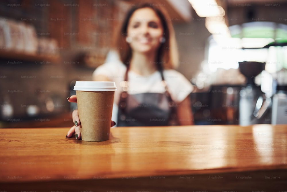 Buying drink. Young female employee indoors. Conception of business and service.