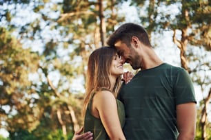 Beautiful young couple have a good time in the forest at daytime.