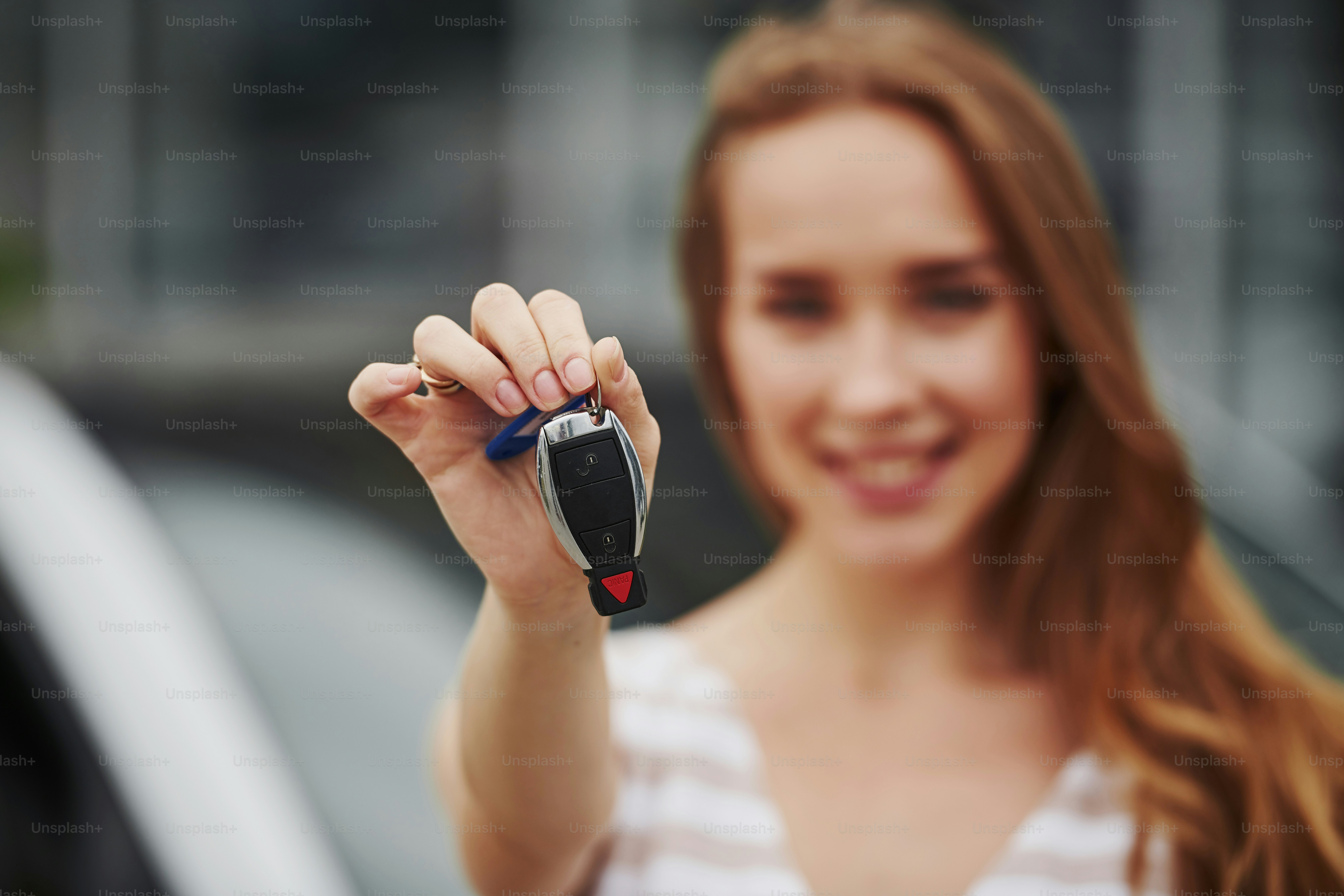 Portrait of cheerful blonde with keys of her brand new car.