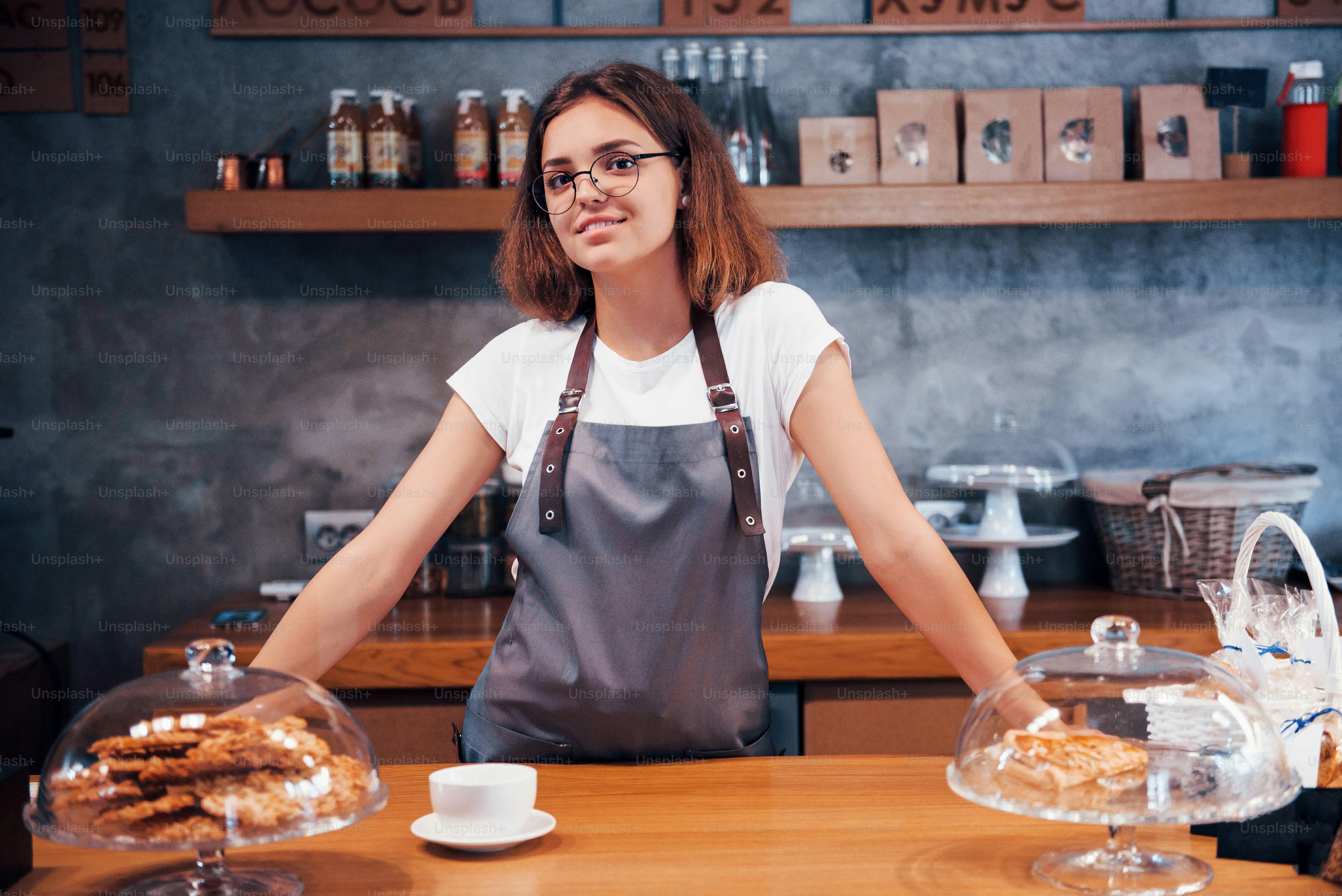 Good mood. Young female cafe worker indoors. Conception of business and service.