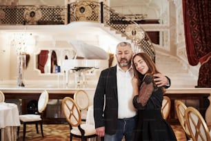 Gives hugs. Picture of grandfather with his granddaughter in aristocratic place.