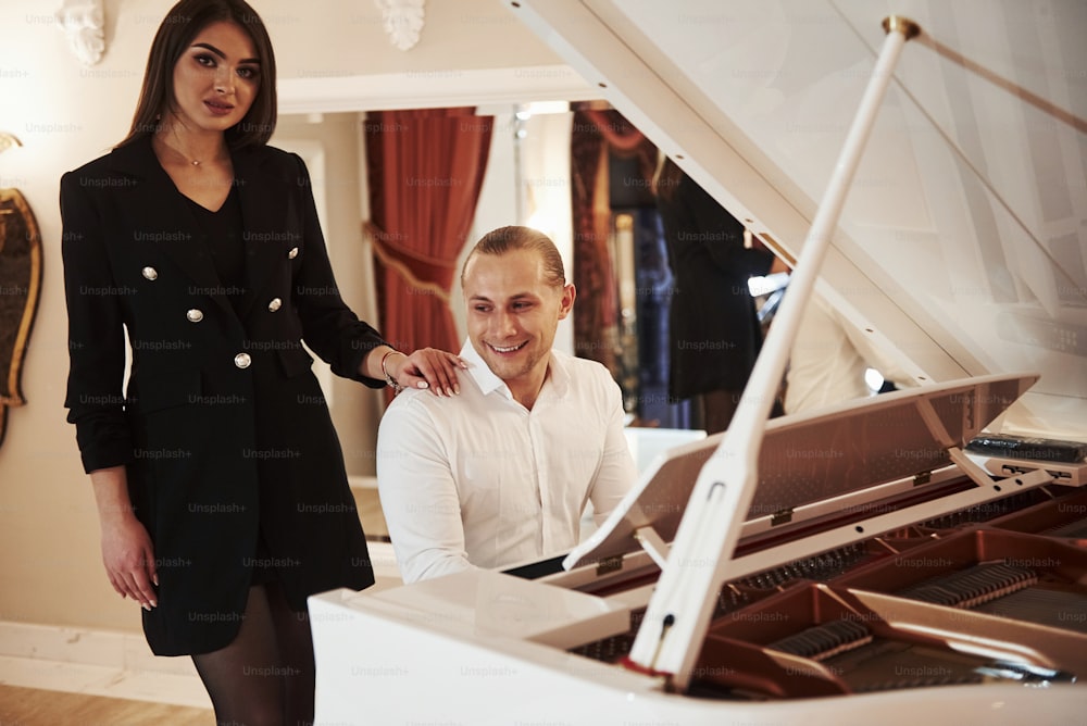 That guy can play piano. Beautiful couple have romantic dinner in luxury restaurant at evening time.