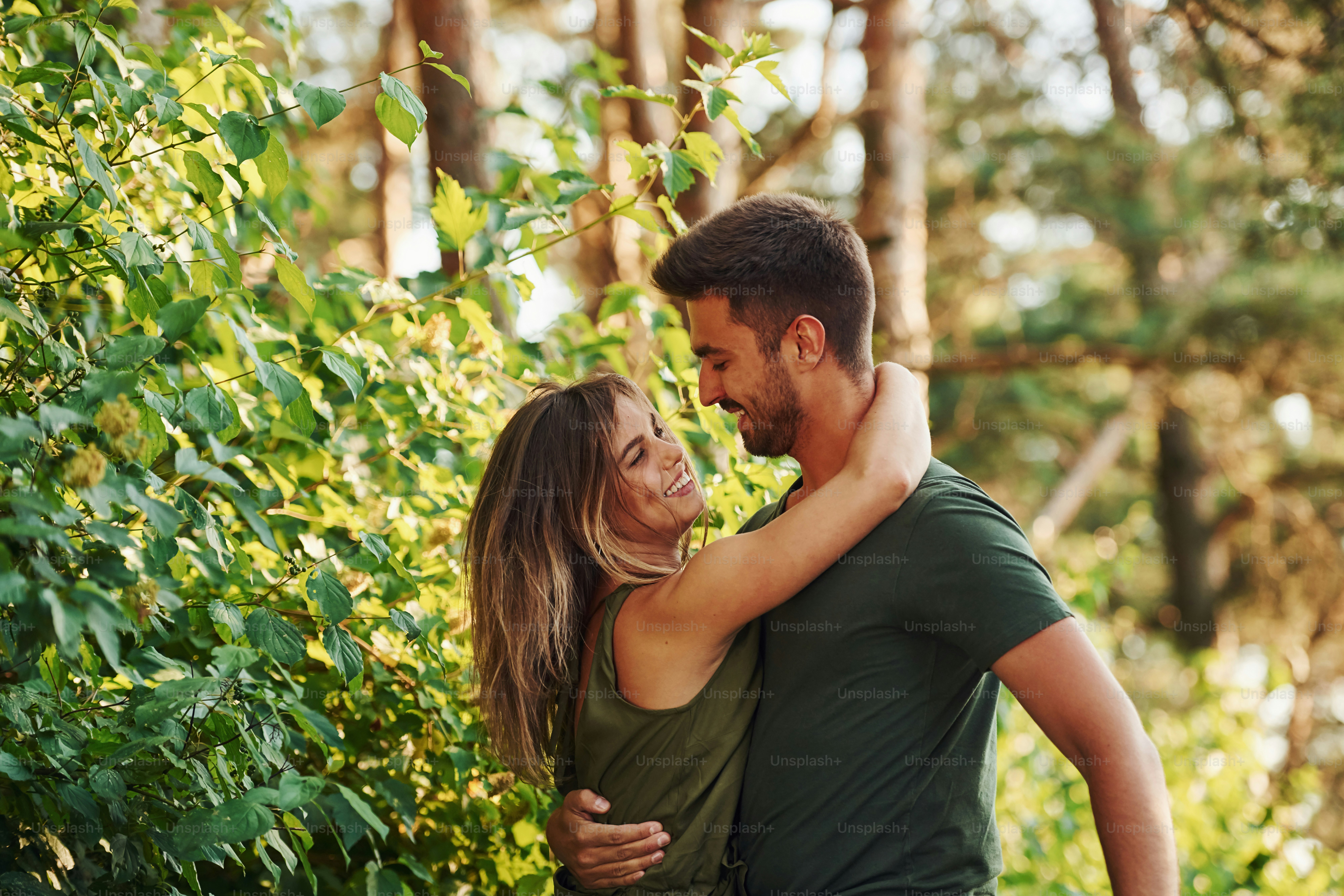 Closeness of people. Beautiful young couple have a good time in the forest at daytime.