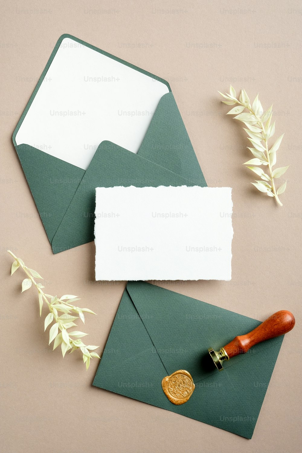 Sobres verdes vintage con sello de cera, tarjeta de papel en blanco, flores secas sobre fondo beige en pasta. Maqueta de invitación de boda de estilo retro, plantilla de tarjeta de felicitación para cumpleaños.