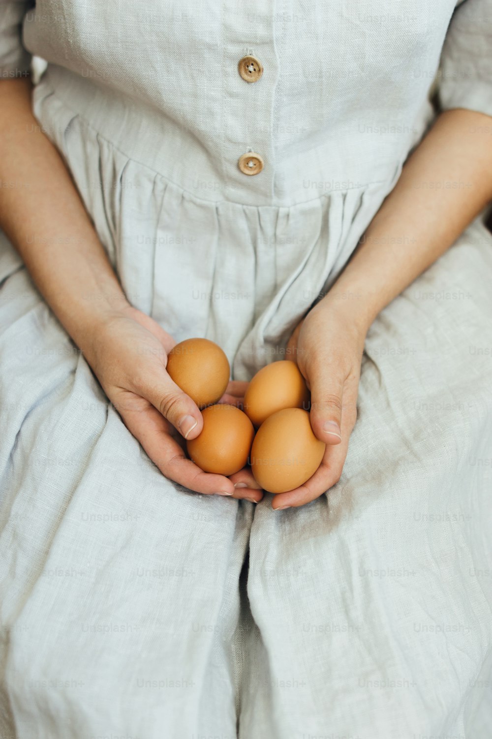 Woman in rustic linen dress holding natural easter eggs  in hands. Happy Easter! Natural eco eggs. Aesthetic holiday, stylish image