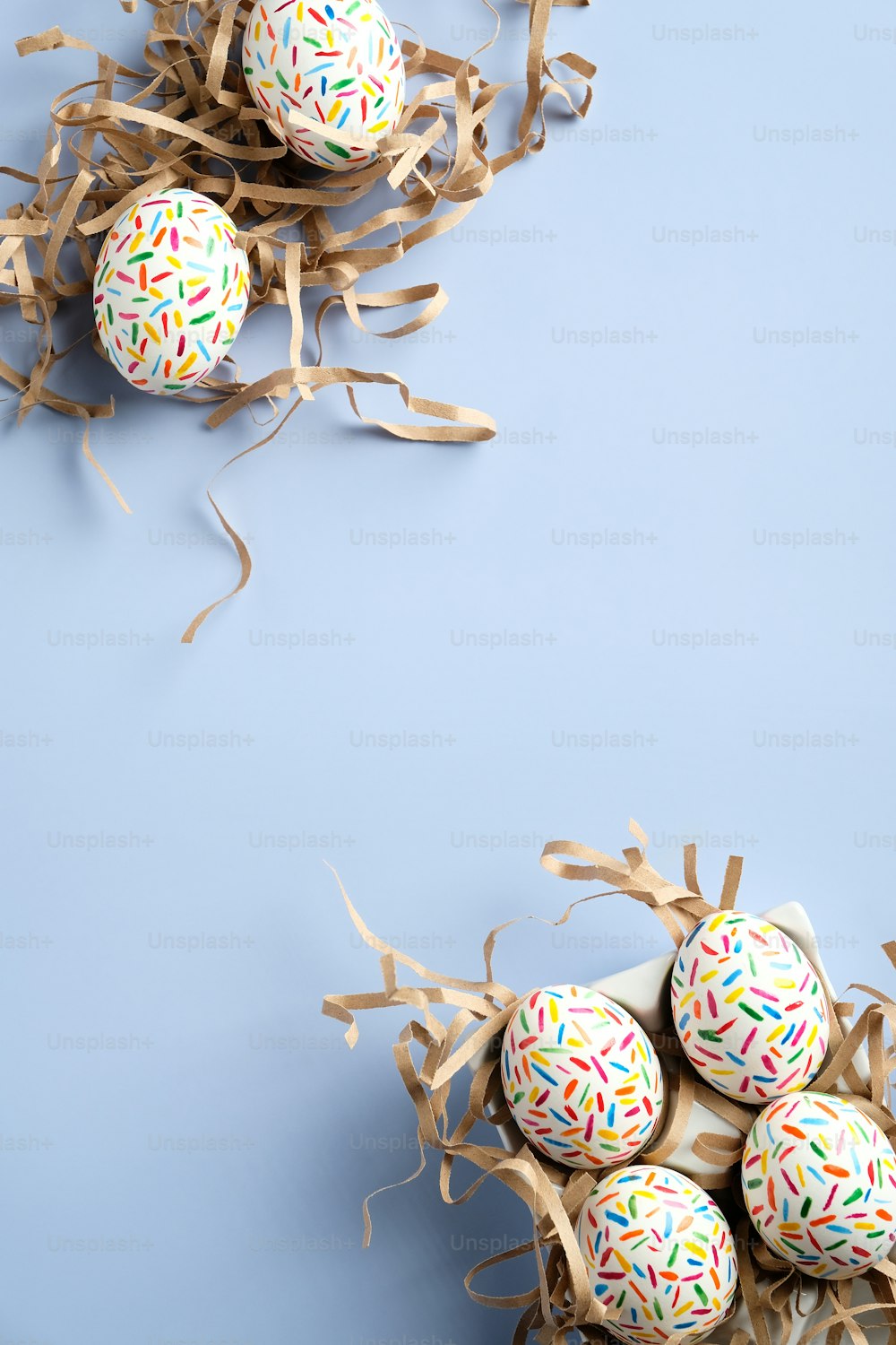 Happy Easter vertical banner template. Colorful Easter eggs in nest on blue background. Minimal style. Flat lay, top view.