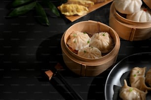 Cropped shot of Dimsum dumplings on bamboo steamer on dinning table in Chinese restaurant