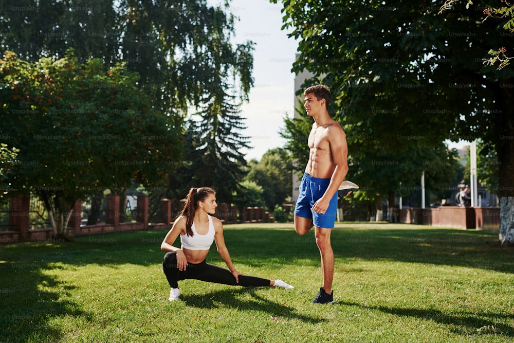 Preparando-se para o exercício. Homem e mulher têm dia de fitness na cidade durante o dia no parque.