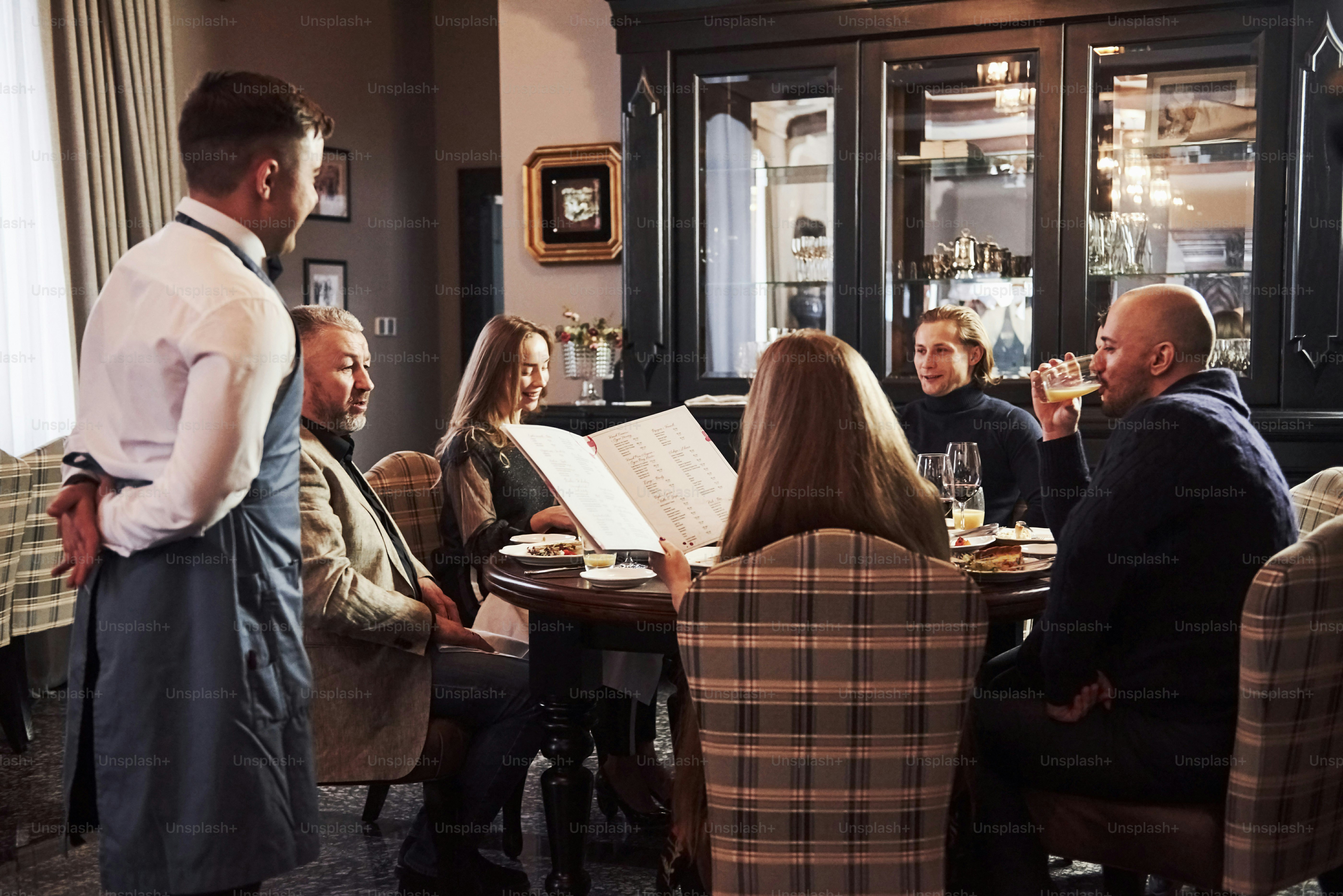 Waiter is waiting for an order. Family friends having nice time in ...