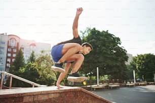 Natural lighting. Young sports man doing parkour in the city at sunny daytime.