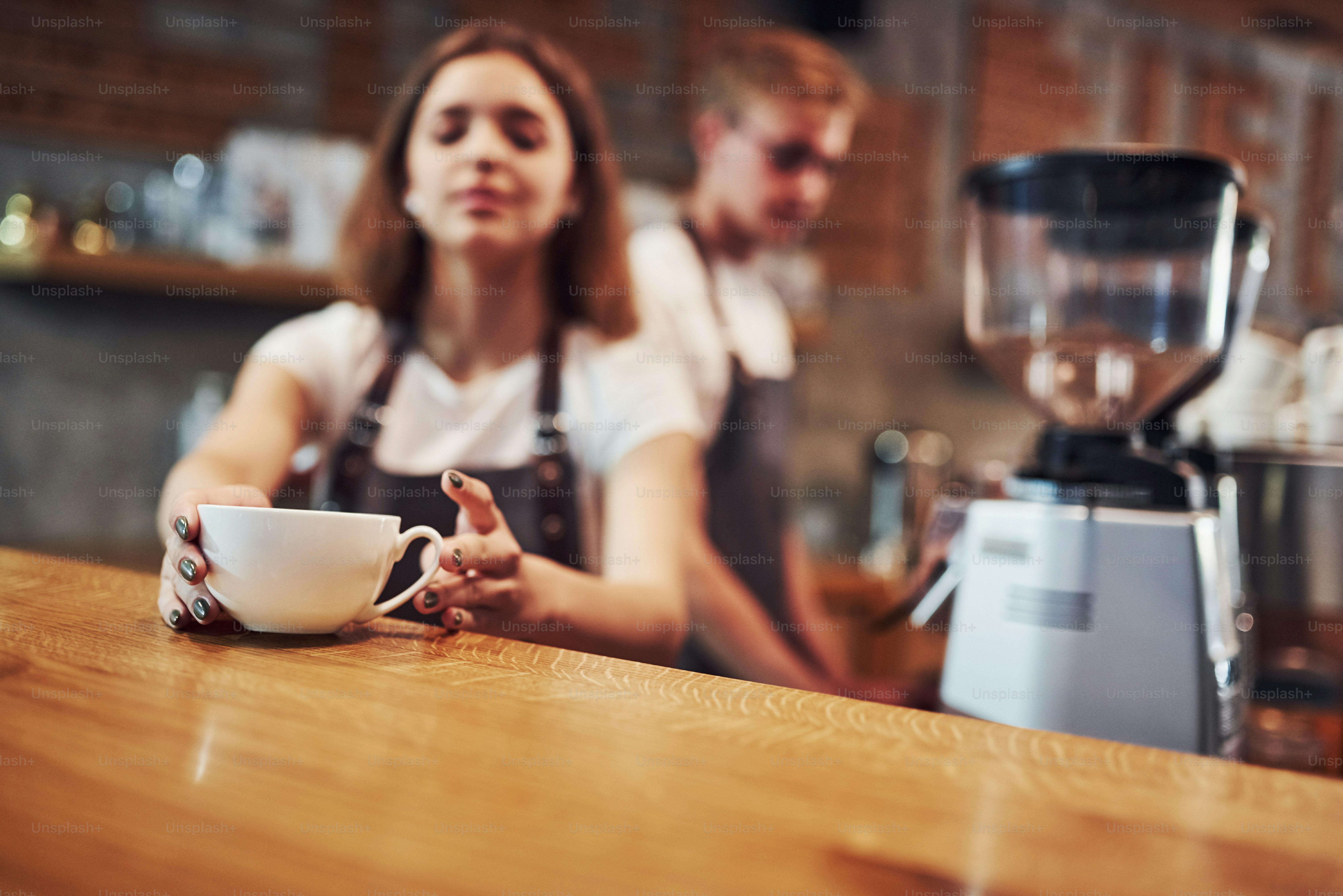 Your drink is ready. Two young cafe workers indoors. Conception of ...
