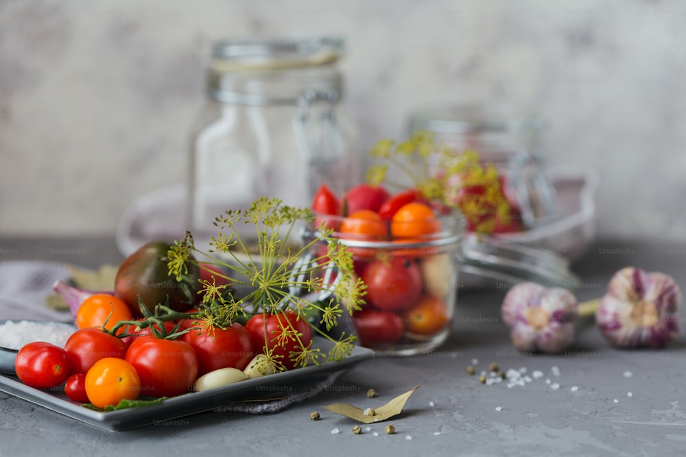 Ingredientes para fazer comida vegana saudável. Legumes em conserva. Tomates sendo preparados para preservação. Alimentação limpa, conceito de comida vegetariana