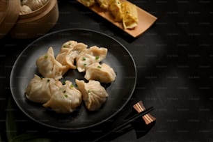 Top view of a plate of dumplings on dinning table with chopstick and copy space in Chinese restaurant