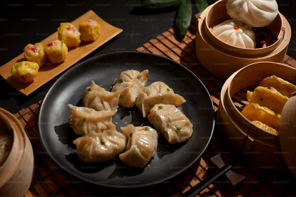 Cropped shot of a plate and bamboo steamer of Dimsum dumplings in Chinese restaurant