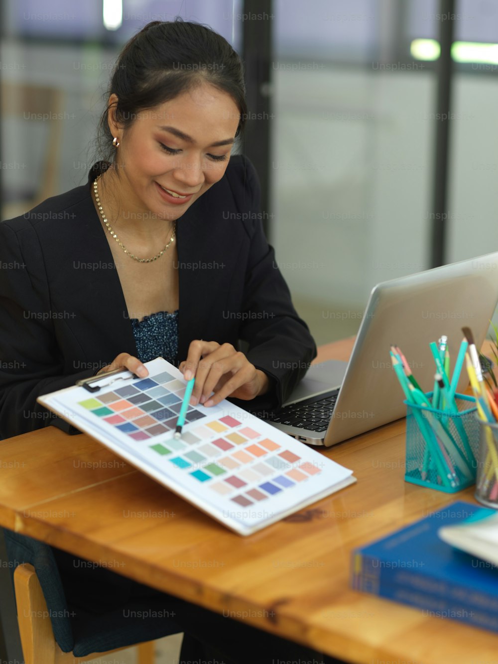 Ritratto di designer femminile che mostra la tabella dei colori al suo collega mentre si consulta sul loro progetto