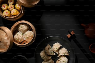 Vista dall'alto di Dimsum sul piatto e vaporiera di bambù con gnocchi sul tavolo con spazio di copia nel ristorante cinese