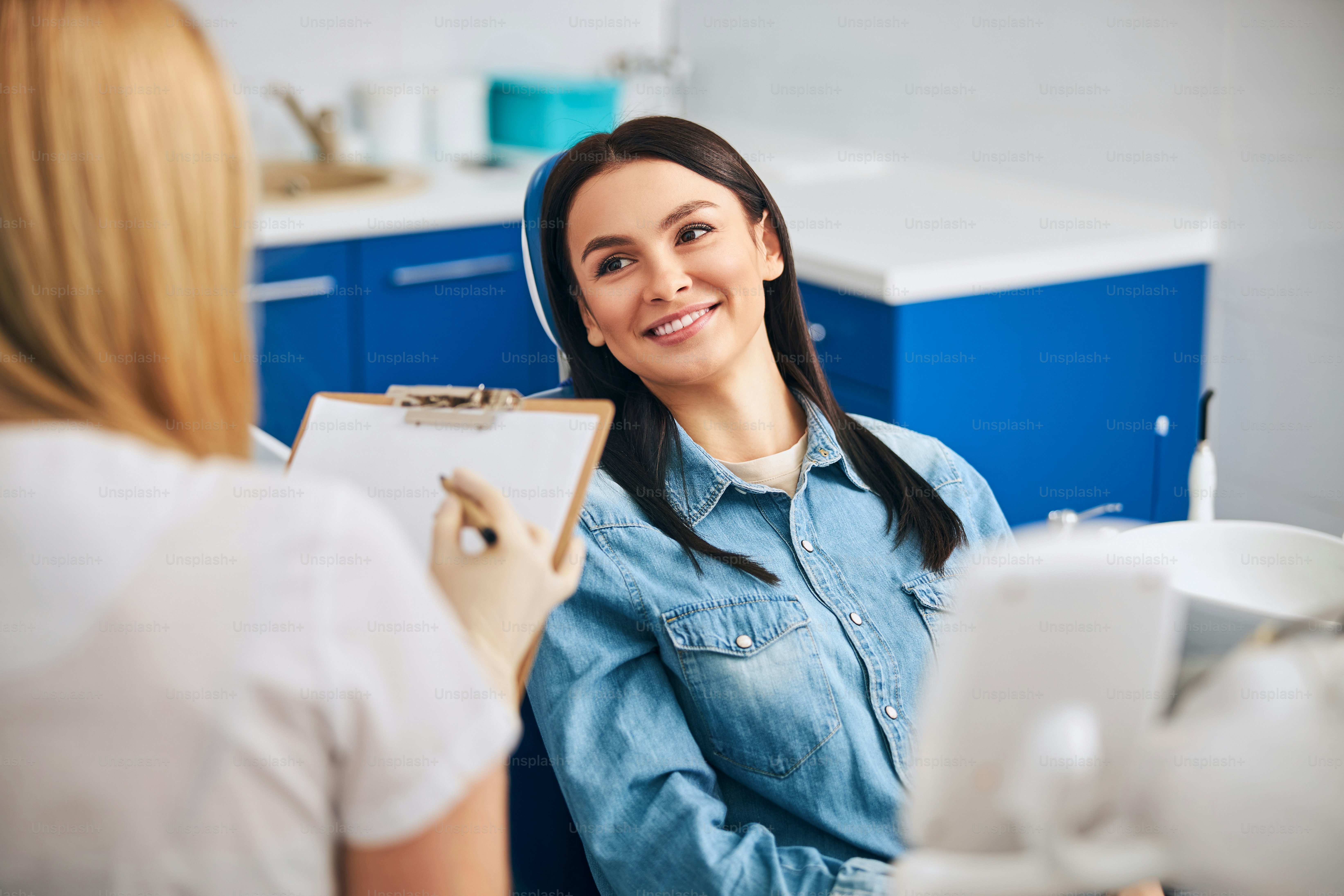 Professioneller Zahnarzt in Uniform bei der Arbeit im Schrank mit dem Patienten