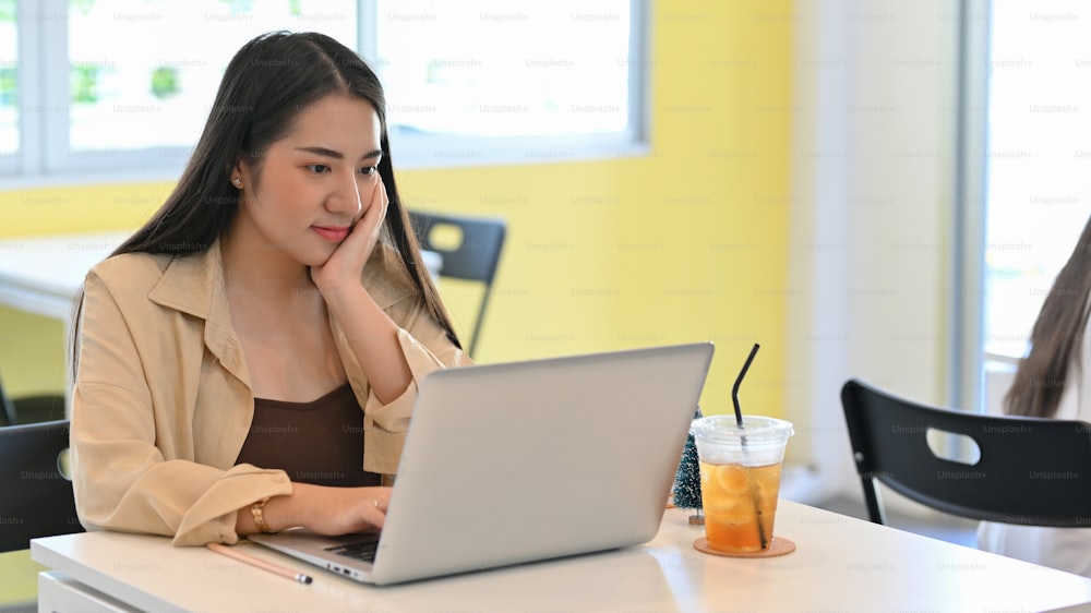 Close up view of businesswoman working with laptop on the table in co-working space