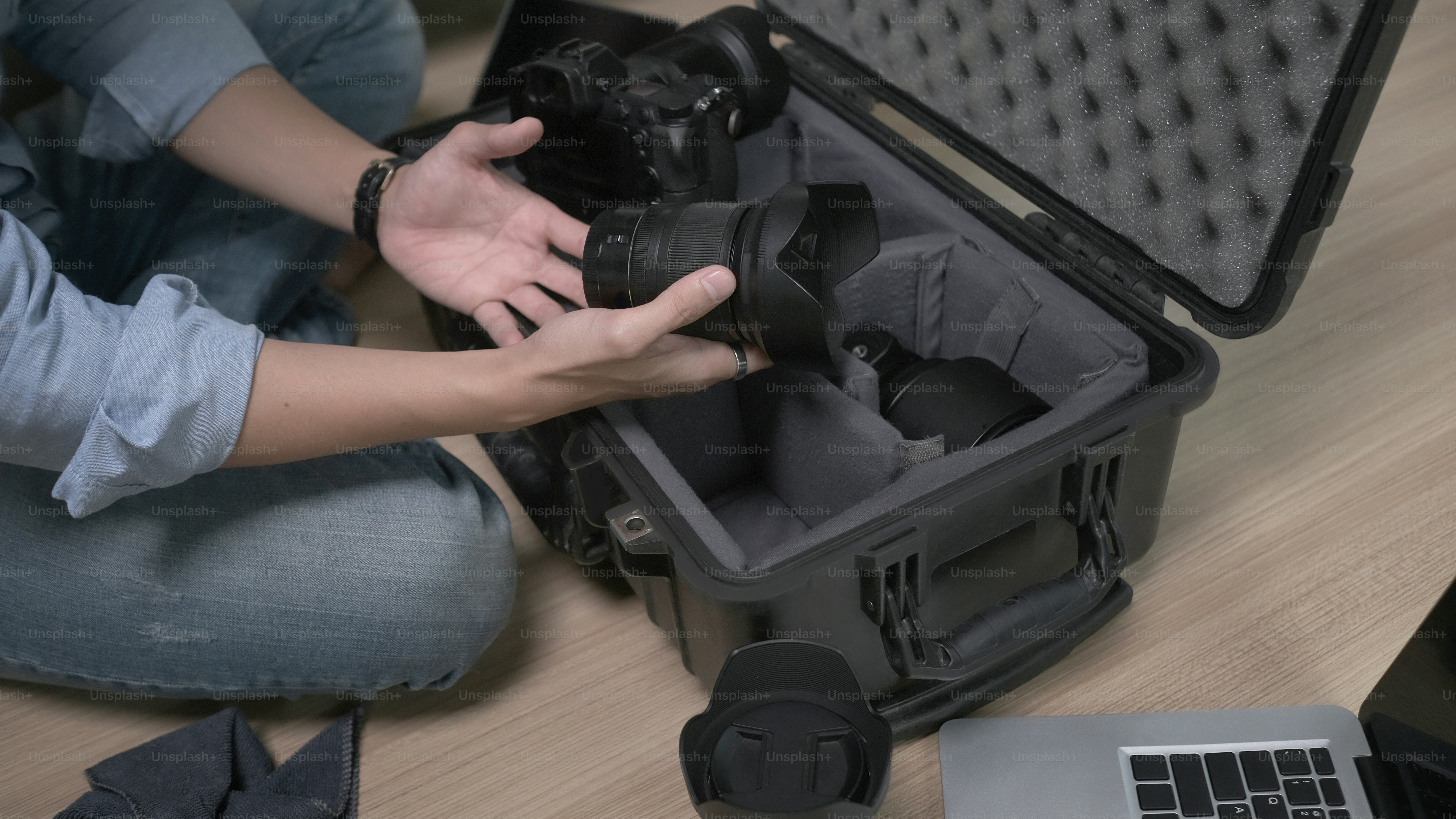 Cropped shot of man photographer hands putting camera accessories in the bag.