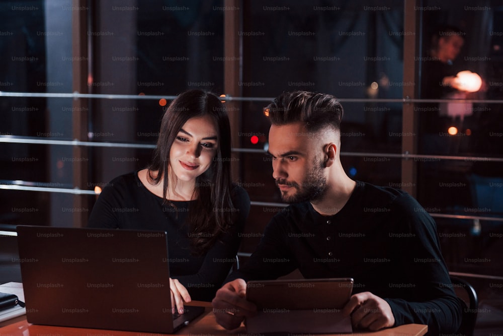 Let's see the results. Team of young business people works on their project at night time in the office.