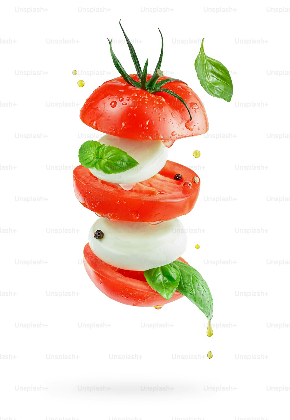 Ensalada caprese italiana voladora con queso mozzarella, tomates y albahaca aislados en blanco