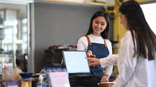 Young female waitress showing electronic menu and recommend something special to customer.